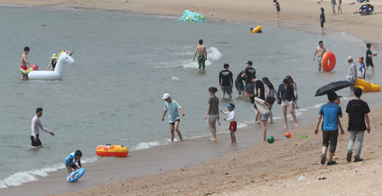 19일 인천지역 낮 기온이 30도를 넘는 날씨 속에 해수욕장에서 피서객들이 물놀이를 즐기고 있다. /연합뉴스