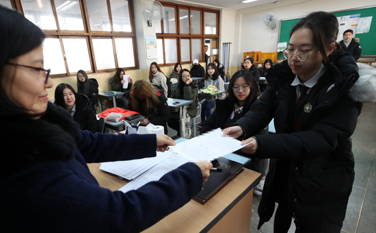 2018학년도 대입수학능력시험 성적표 배부일인 12일 서울 광진구 광남고등학교에서 학생들이 성적표를 받고 있다. /연합뉴스