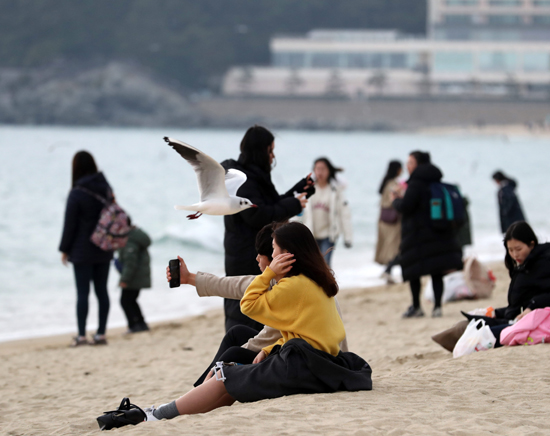 포근한 날씨를 보인 25일 오후 부산 해운대해수욕장에서 시민들이 주말을 즐기고있다. /연합뉴스