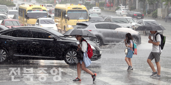 11일 오후 갑작스런 폭우가 쏟아진 전주시내에서 하교하는 학생들이 우산을 쓰고 횡단보도를 건너고 있다./김현표기자