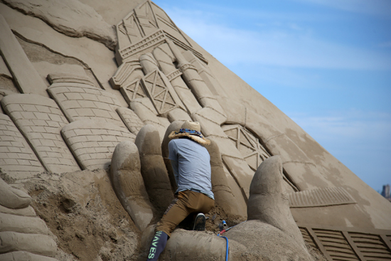 18일 경북 포항 영일대해수욕장에서 한 모래 조각가가 조심스럽게 작품을 만들고 있다. /연합뉴스