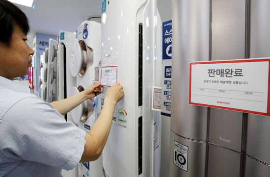 29일 서울의 한 전자제품 판매점에서 직원이 판매완료된 에어컨에 안내문을 붙이고 있다. /연합뉴스