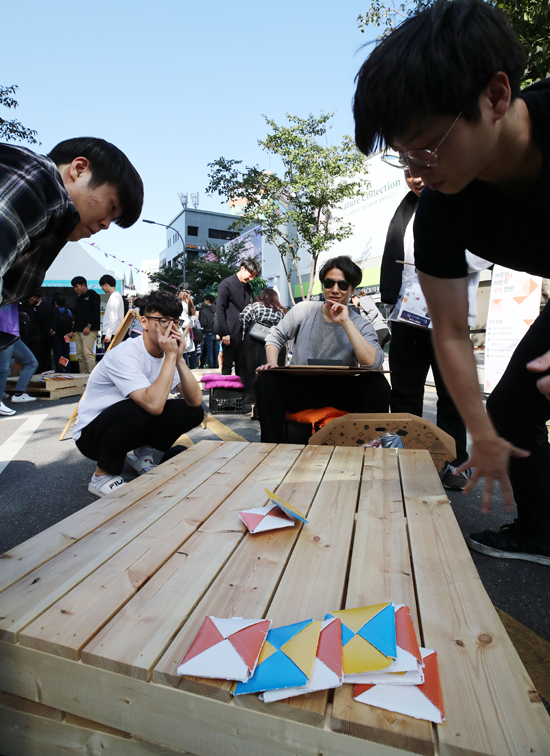 30일 오후 서울 서대문구 연세로 일대에서 열린 청년 스타트업 거리축제 'IF 2018'을 방문한 시민들이 딱지치기를 하고 있다. /연합뉴스