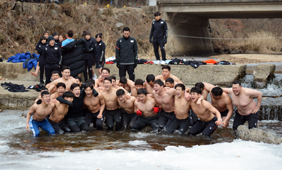 레슬링 남자대표팀 선수들이 15일 충청북도 보은군 속리산 국립공원 내 계곡에서 얼음물에 입수하고 있다. /연합뉴스