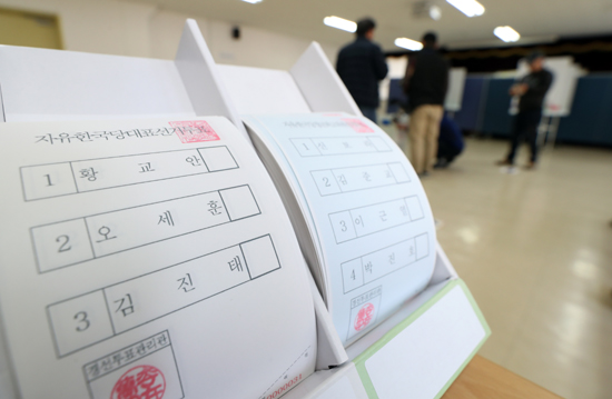 자유한국당 새 지도부 선출을 위한 시·군·구 현장투표일인 24일 서울 영등포구선관위에서 한 당원이 투표용지에 기표를 한 뒤 투표함으로 향하고 있다.