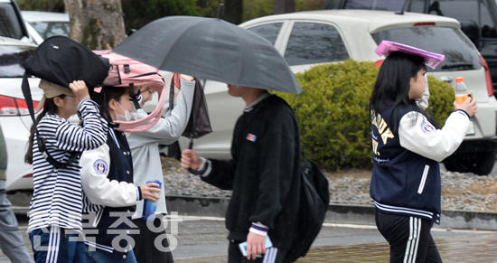 봄비가 내린 9일 전북대학교에서 학생들이 우산 대신 책가방으로 비를 피하고 있다./이원철기자