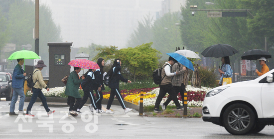 봄비가 촉촉히 내린 25일 전주시 서신동 롯데백화점 사거리에서 시민들이 우산을 받고 신호등을 건너고 있다./이원철기자