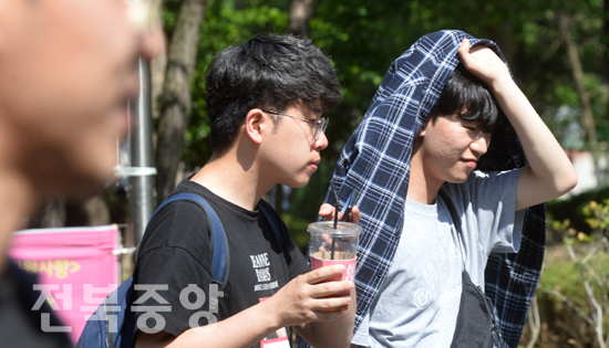 초여름 날씨를 보인 22일 전북대학교 교정에서 한 학생이 강한 햇볕을 피하기 위해 긴팔셔츠를 머리위에 쓰고 이동을 하고 있다./이원철기자