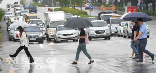 장맛비가 내린 10일 전북대학교 사거리에서 시민들이 우산을 받고 신호등을 건너고 있다./이원철기자