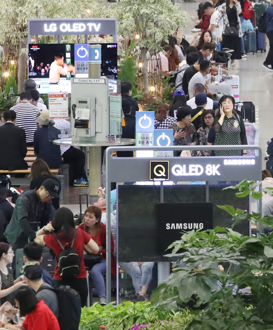 삼성전자와 LG전자가 8K TV 기술을 놓고 정면충돌하는 양상이다. 사진은 17일 인천국제공항에 설치된 삼성전자 QLED TV와 LG OLED TV. /연합뉴스