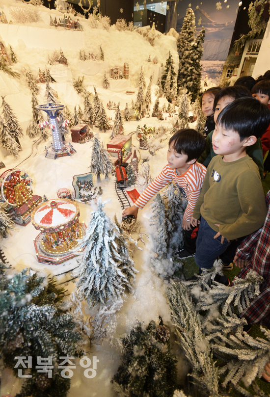 성탄절 휴일을 맞아 25일 전북은행 1층에 마련된 'JB원더랜드'를 찾은 어린이들이 동화속 세상같은 조형물 풍경 등을 관람하고 있다./이원철기자