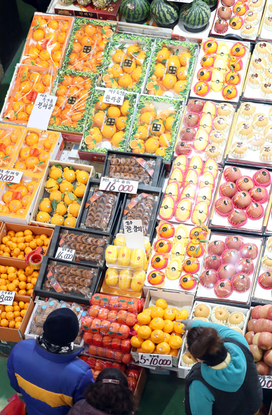19일 부산 해운대구 반여농산물도매시장에서 시민들이 설을 앞두고 제수용 과일을 고르고 있다. /연합뉴스