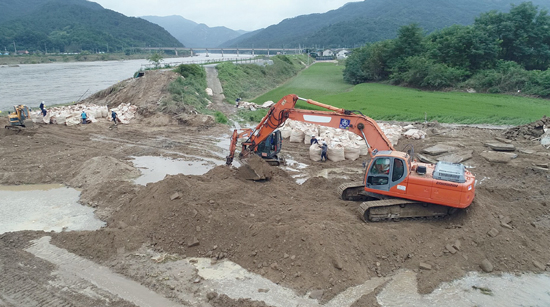 지난 폭우로 붕괴된 전북 남원시 금지면 일대의 섬진강 둑을 응급 복구하는 작업이 11일 중장비가 동원돼 진행되고 있다. /연합뉴스