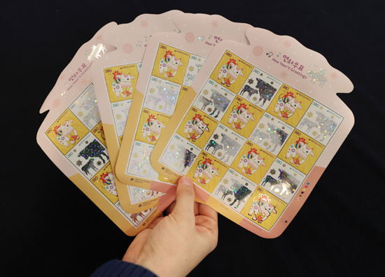 1일 서울 중구 우표박물관에서 한 직원이 '흰 소의 해'인 신축년(辛丑年)을 맞아 발행된 2021년 연하 우표를 선보이고 있다. /연합뉴스