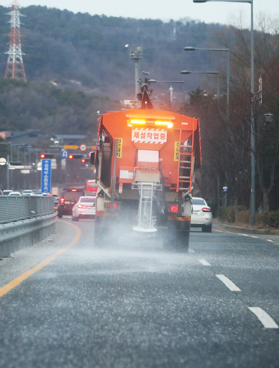 밤사이 많은 눈이 예보된 3일 오후 경기도 수원시 영통구의 한 도로에서 제설차가 제설제를 살포하고 있다. /연합뉴스