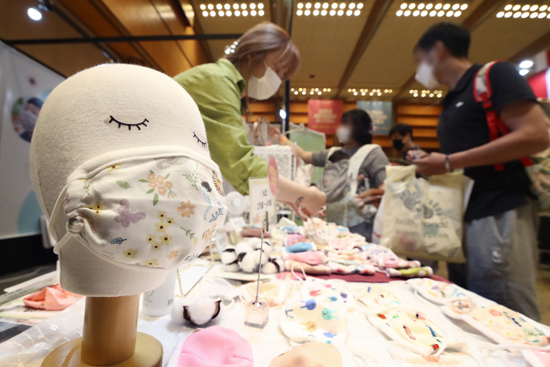 3일 서울 강남구 코엑스에서 열린 글로벌 베이비페어를 찾은 관람객들이 유아용 마스크를 살펴보고 있다. /연합뉴스