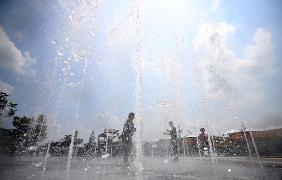 낮 최고기온이 33도를 웃돈 12일 오후 바닥분수에서 시민들이 시원한 물줄기로 더위를 식히고 있다. /연합뉴스