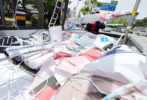 한 관계자가 제8회 전국동시지방선거 후보들의 홍보 현수막을 철거 후 차량에 싣고 있다. /연합뉴스