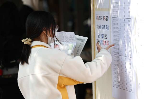 2024학년도 대학수학능력시험 예비소집일인 15일 한 여자고등학교에서 수험생들이 시험실 배치도를 확인하고 있다. /연합뉴스
