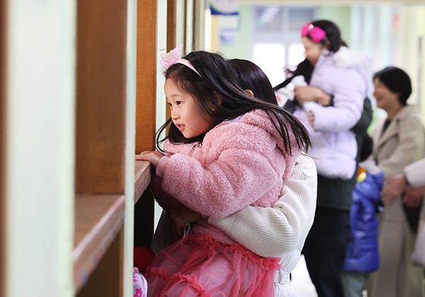 26일 오후 한 초등학교에서 열린 신입생 예비 소집에서 예비 초등학생이 부모님과 교실을 살펴보고 있다. /연합뉴스