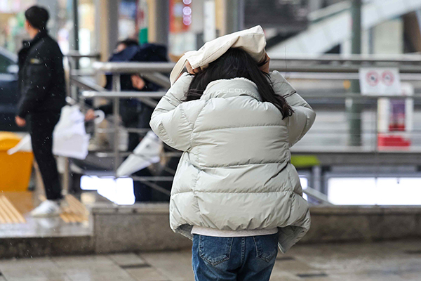 비가 내린 14일 오후 도심거리에서 한 시민이 가방으로 머리를 가리고 뛰고 있다. /연합뉴스