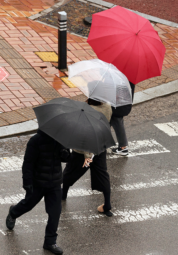 18일 오전 도심에서 시민들이 내리는 겨울비에 우산을 쓰고 걷고 있다. /연합뉴스
