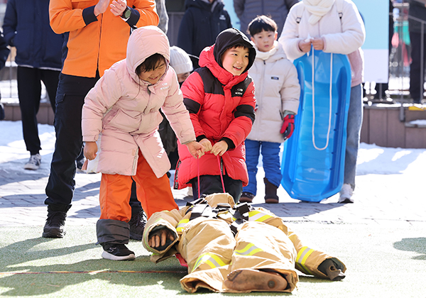 25일 '길거리 소방안전체험'에서 참가자들이 눈썰매를 활용한 마네킹 끌기 체험을 하고 있다. /연합뉴스
