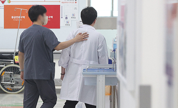 전공의 집단이탈이 장기화하는 가운데 27일 한 대학병원 응급실에서 PA간호사가 의사의 등을 토닥이고 있다. /연합뉴스